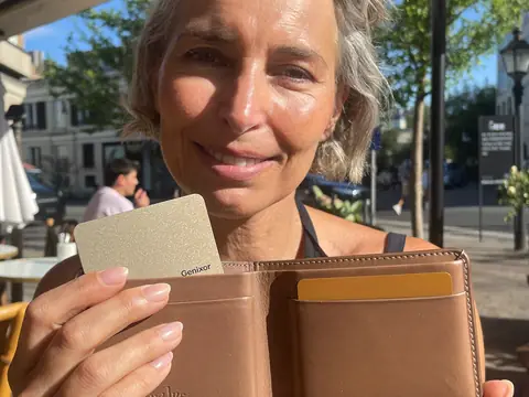 Une femme montre la carte Genixor sortie de son portefeuille
